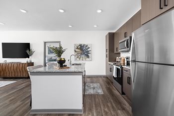 A modern kitchen with a white island and stainless steel appliances.